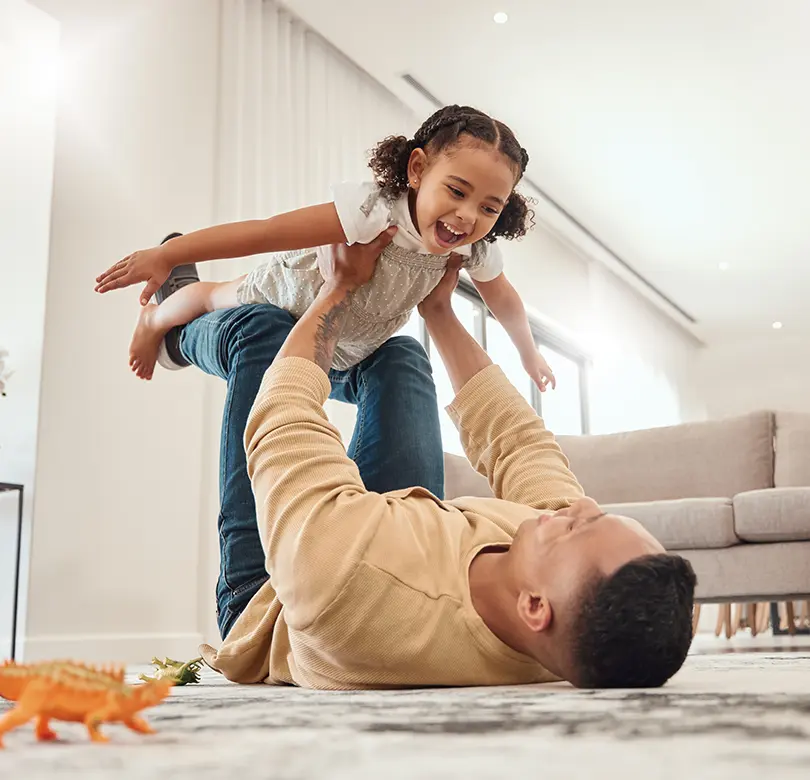 Un père et sa fille jouant à la maison.