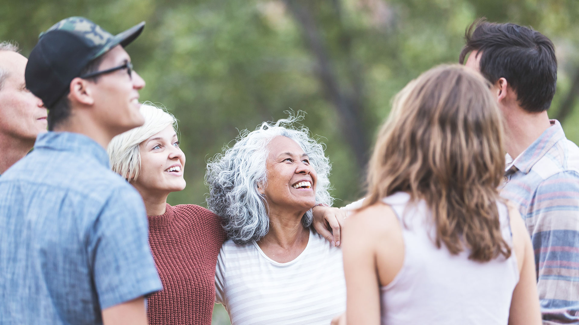Groupe souriant de personnes parlant ensemble à l'extérieur