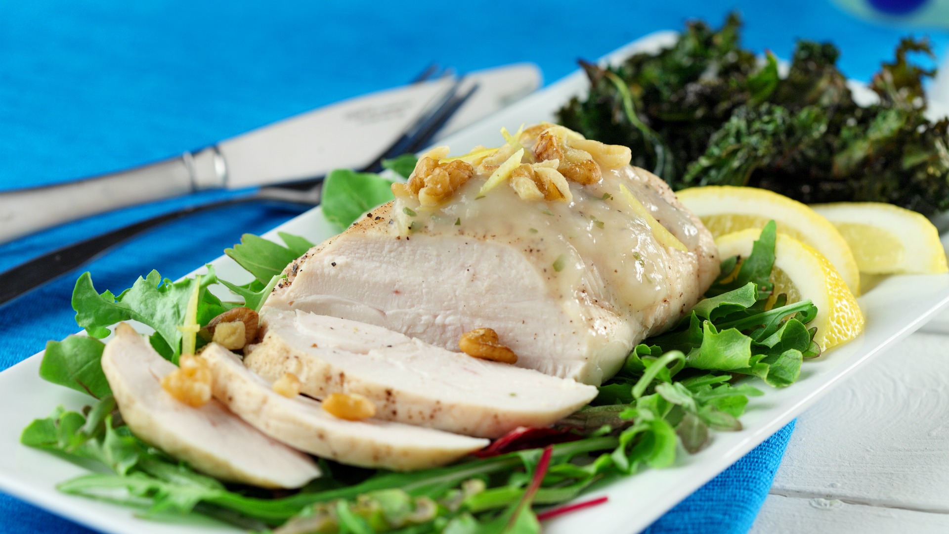 Lemon walnut chicken with kale chips on a bed of lettuce