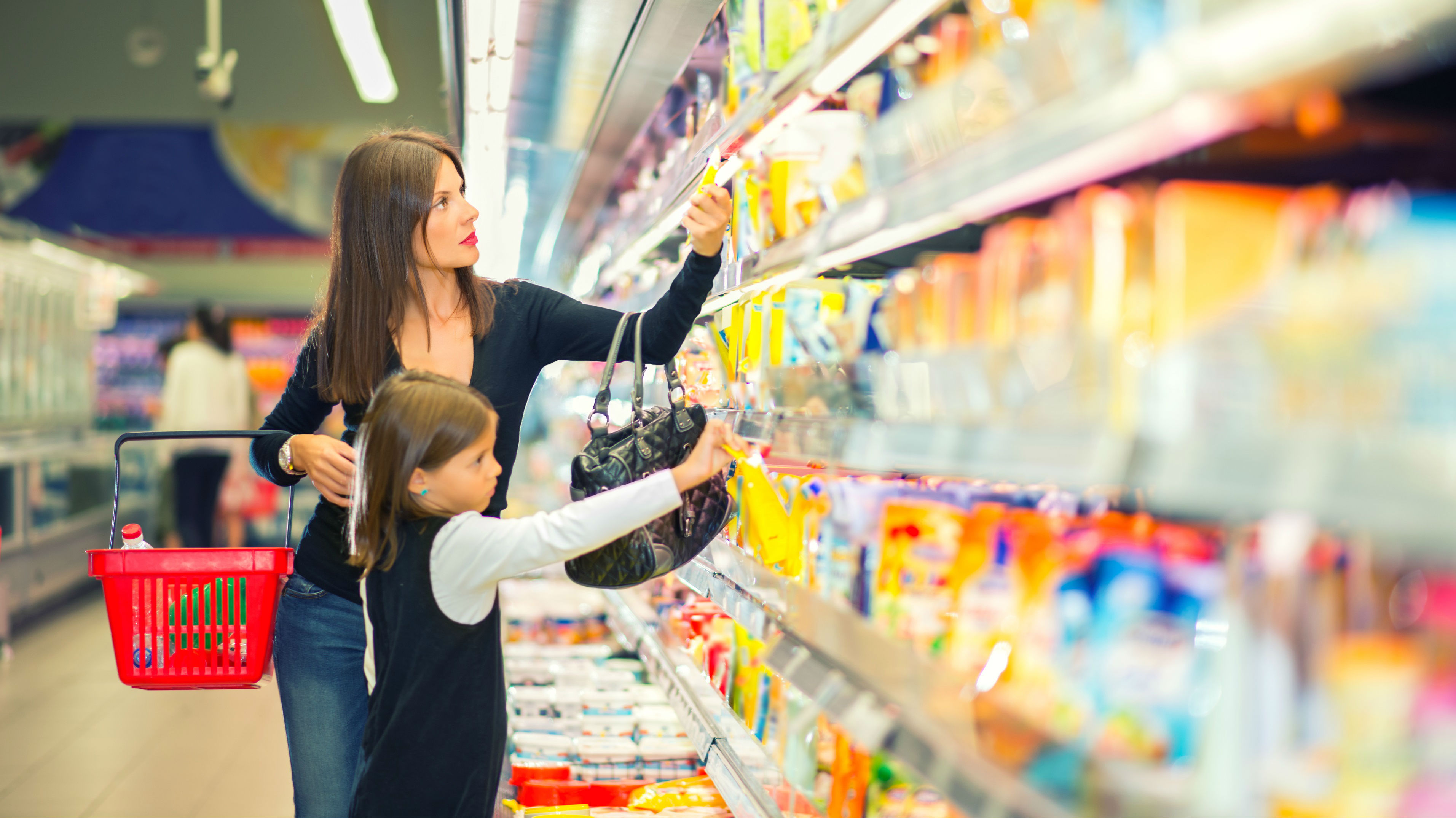 Mère et sa jeune fille font leur épicerie dans l’allée des produits laitiers du supermarché.