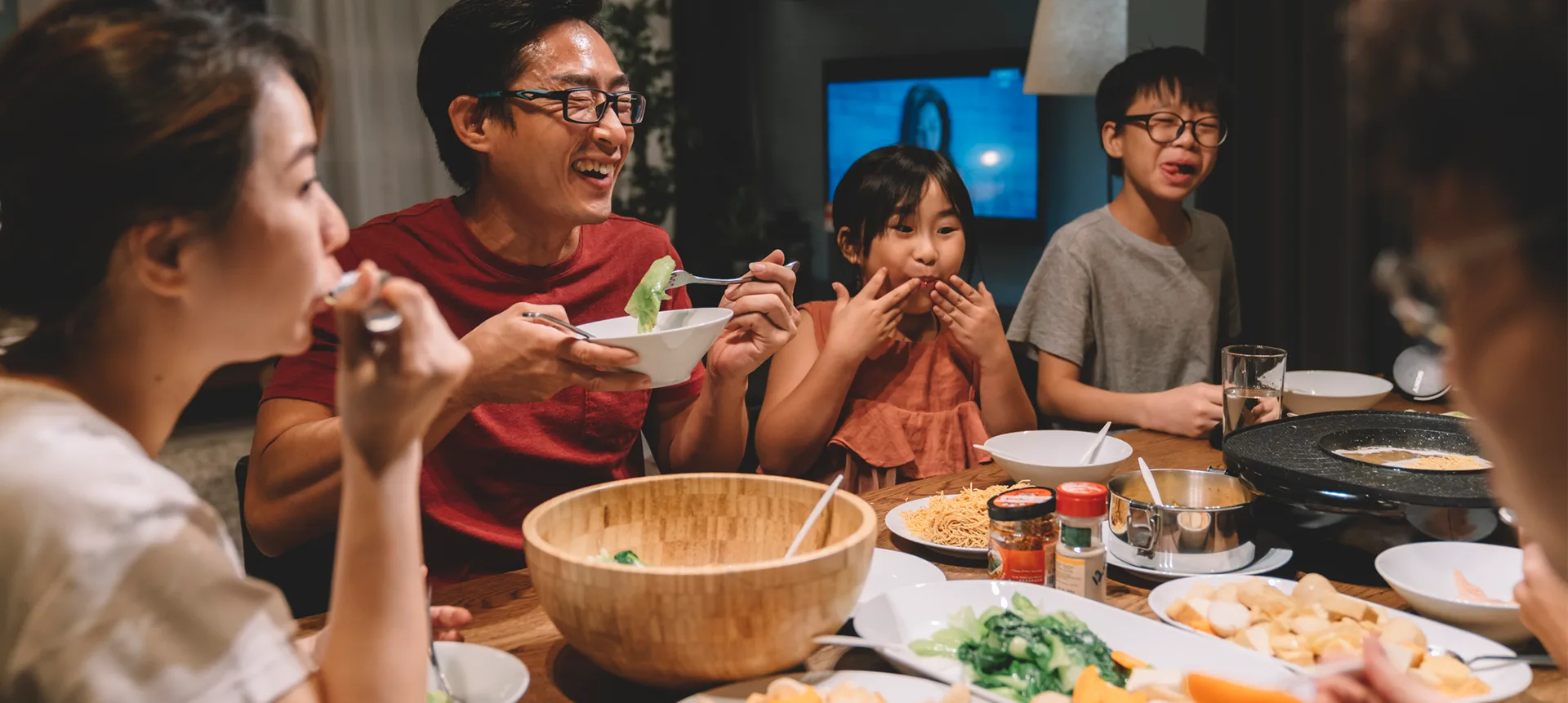 Une famille réunie autour d’une table à manger pour partager un repas.