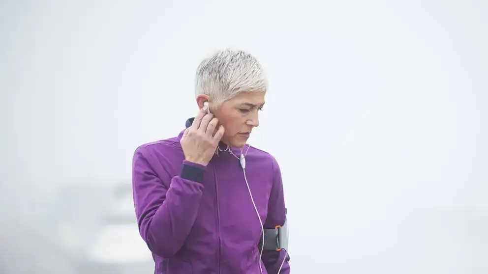Femme écoutant de la musique exerçant à l'extérieur