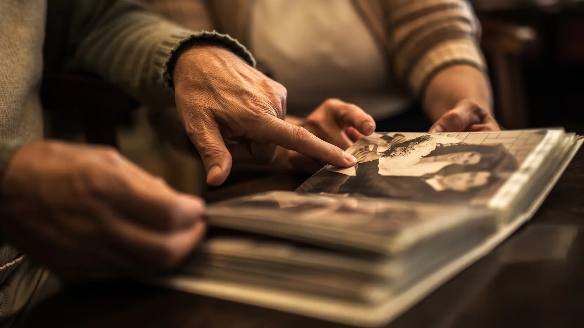 Gros plan d'un couple de personnes âgées en regardant un album photo.