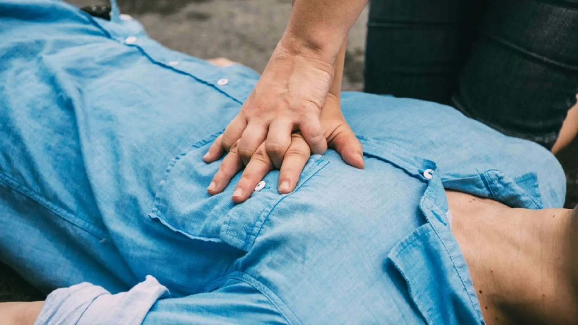Mains pratiquant la RCR sur la poitrine d’un homme
