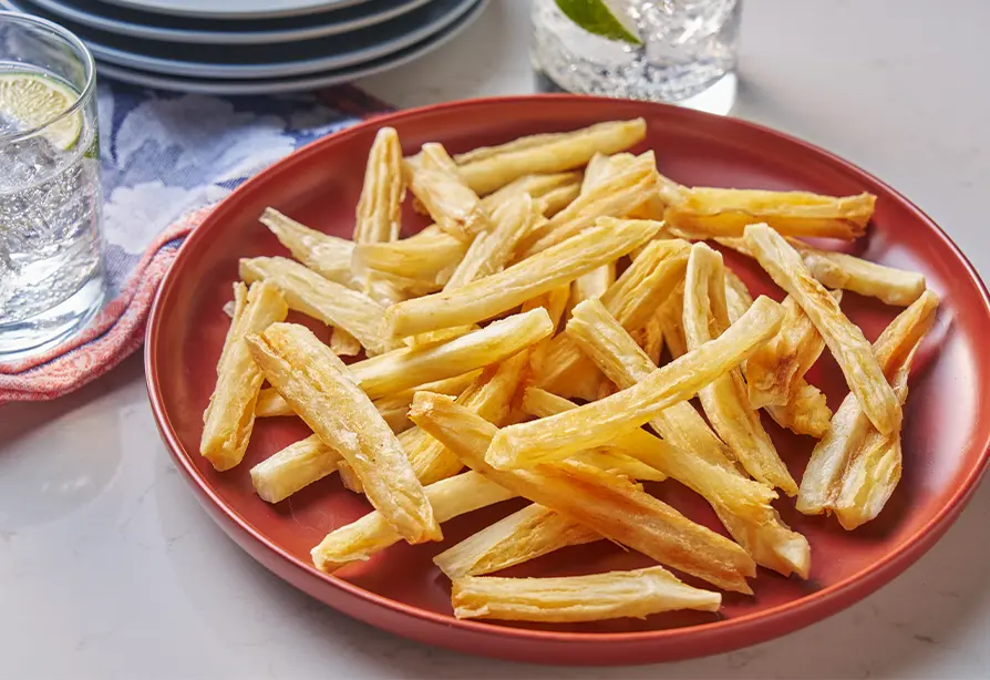 Frites de manioc servies dans une assiette rouge.
