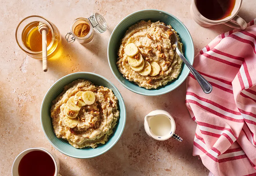 Gruau de millet à la banane servi dans des bols bleus et garni de tranches de bananes. 