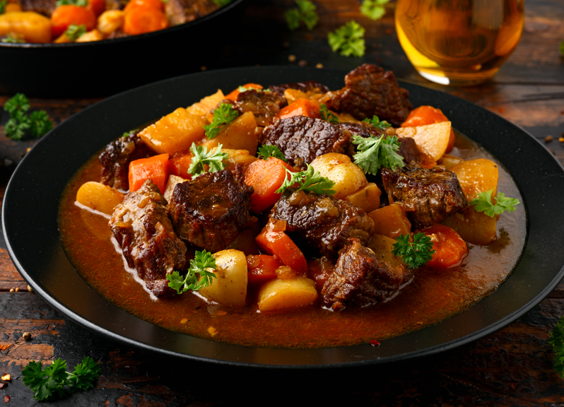 Du ragoût de bœuf aux légumes et aux pommes de terre dans un bol noir. 