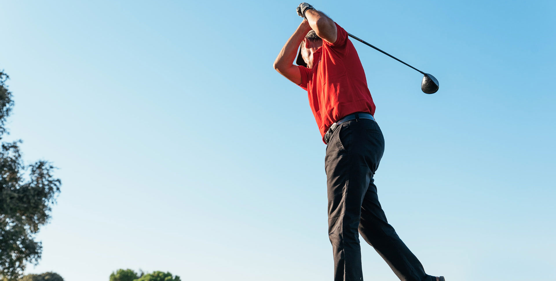 Un homme âgé prépare son élan de golf. 