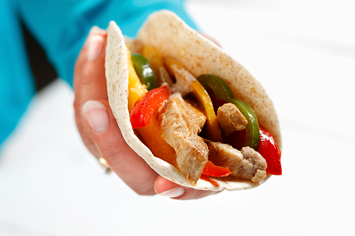 Pork fajitas with mango held in a hand.