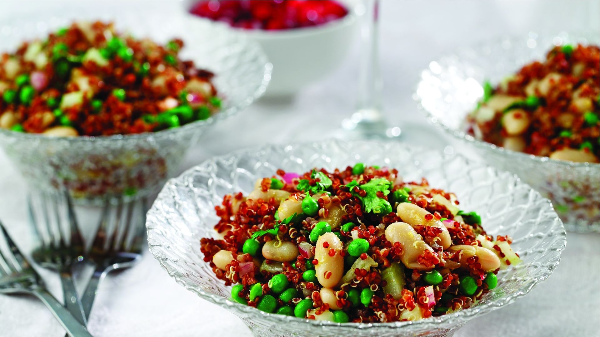 Bols en verre remplis de quinoa, de haricots cannellini, de pois et de coriandre