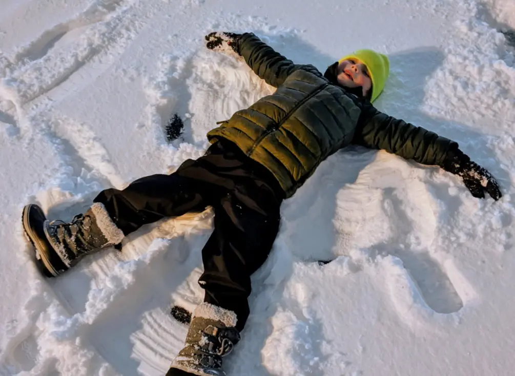 Logan qui fait des anges dans la neige.