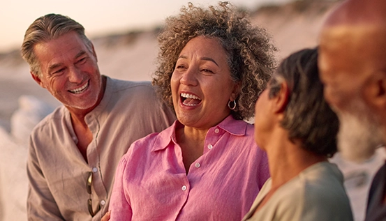 A group of people gathered together, smiling and enjoying each other’s company.	Un groupe de personnes souriantes qui ont du plaisir ensemble.