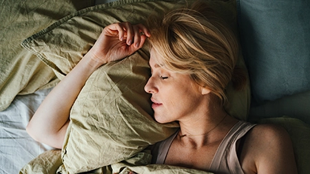 Une personne endormie sur un lit.