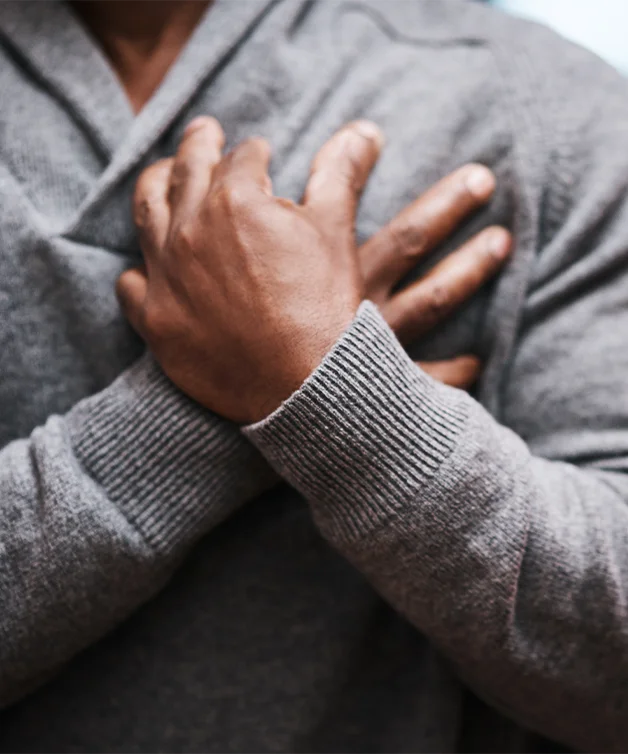 Une personne porte les mains à sa poitrine en proie à la douleur.
