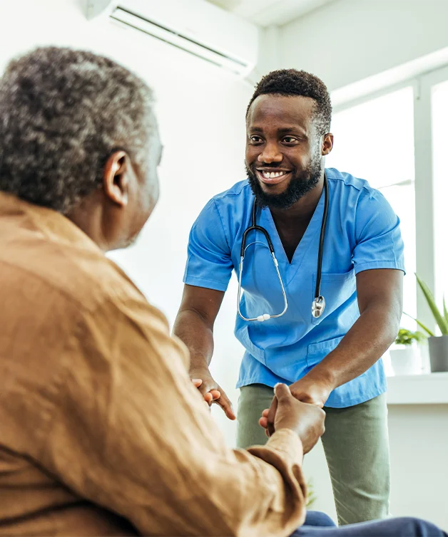 Un médecin encourage un homme âgé en fauteuil roulant.