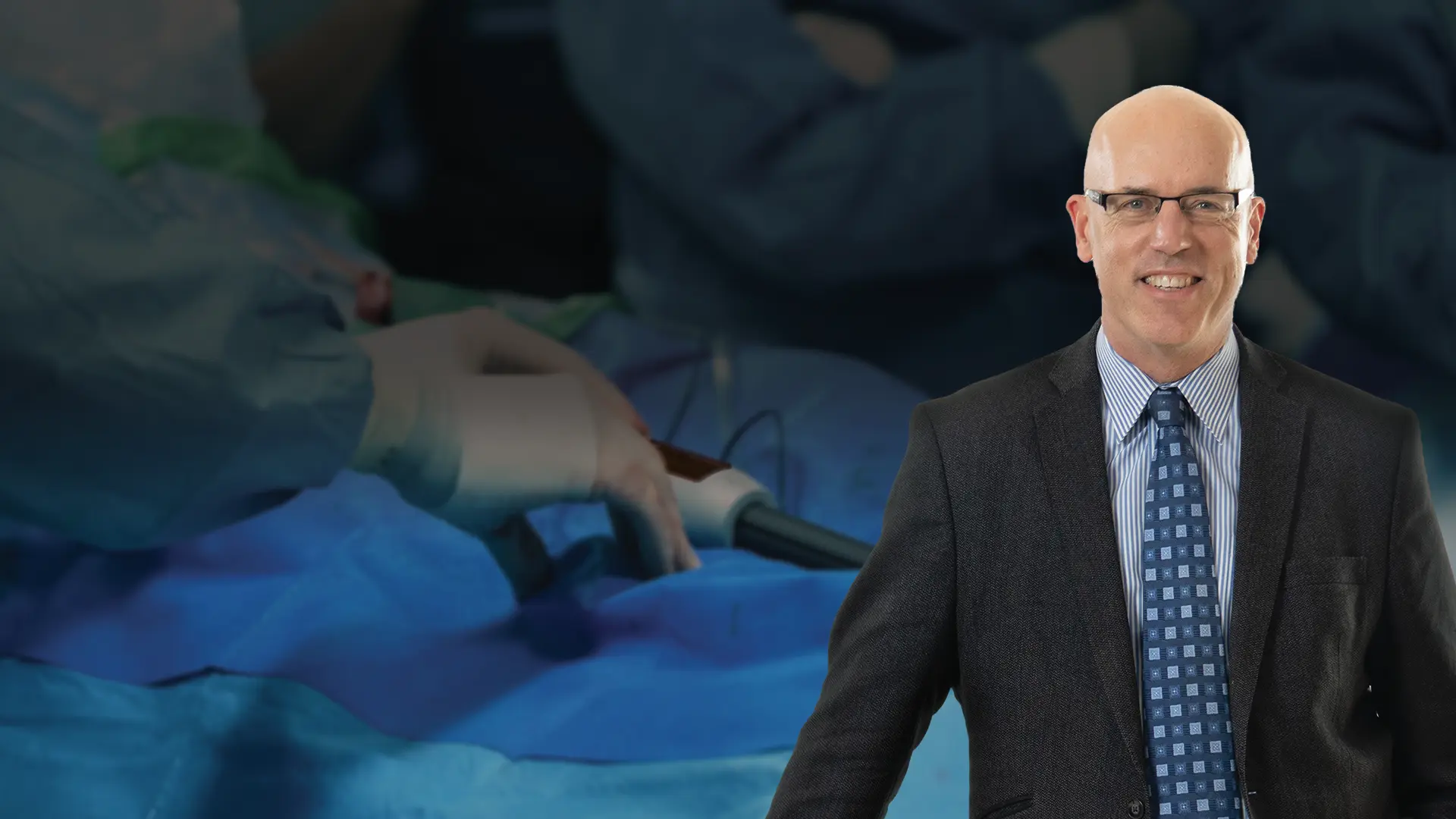 Un chercheur de laboratoire sourit à la caméra tout en tenant une tablette.