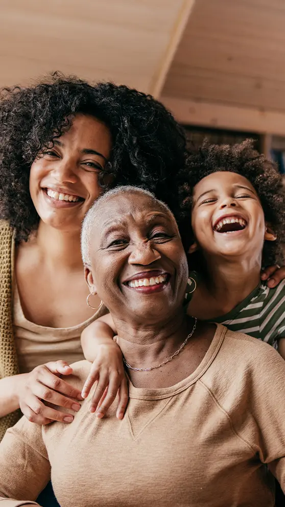 Une grand-mère, une mère et une petite-fille souriant et riant ensemble.