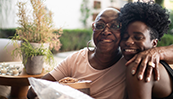 Une mère assise avec ses bras autour de sa fille adulte