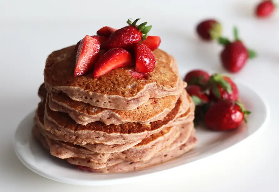 Une pile de pancakes aux fraises dans une assiette