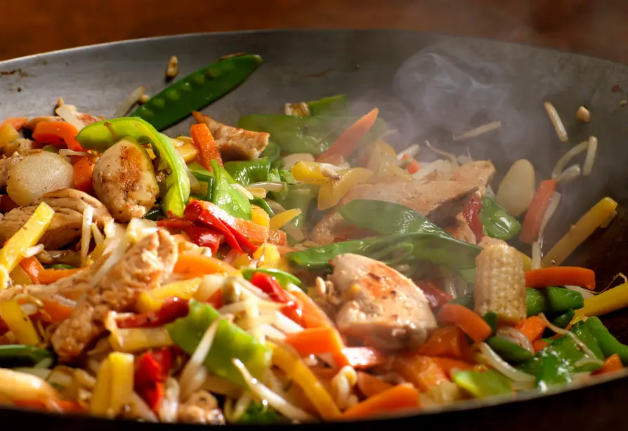 Sauté au poulet et aux légumes hachés dans un wok noir