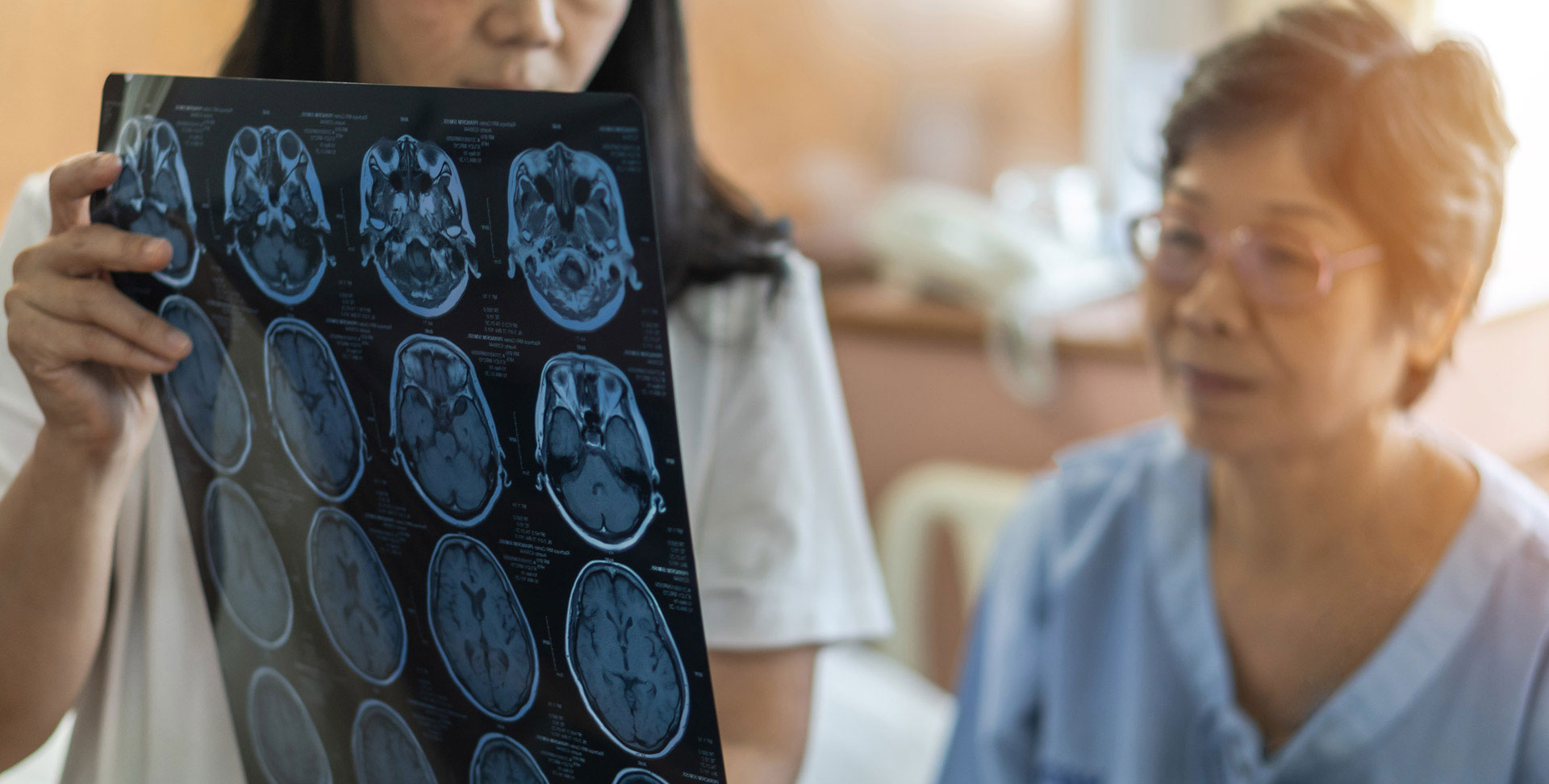 Un médecin montre une feuille de scintigraphies cérébrales et les explique à son patient
