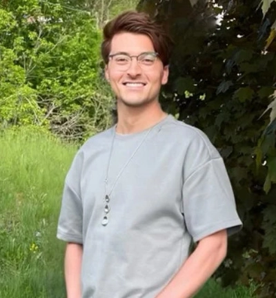 Donald prend la pose à l’extérieur, à côté d’un arbre.