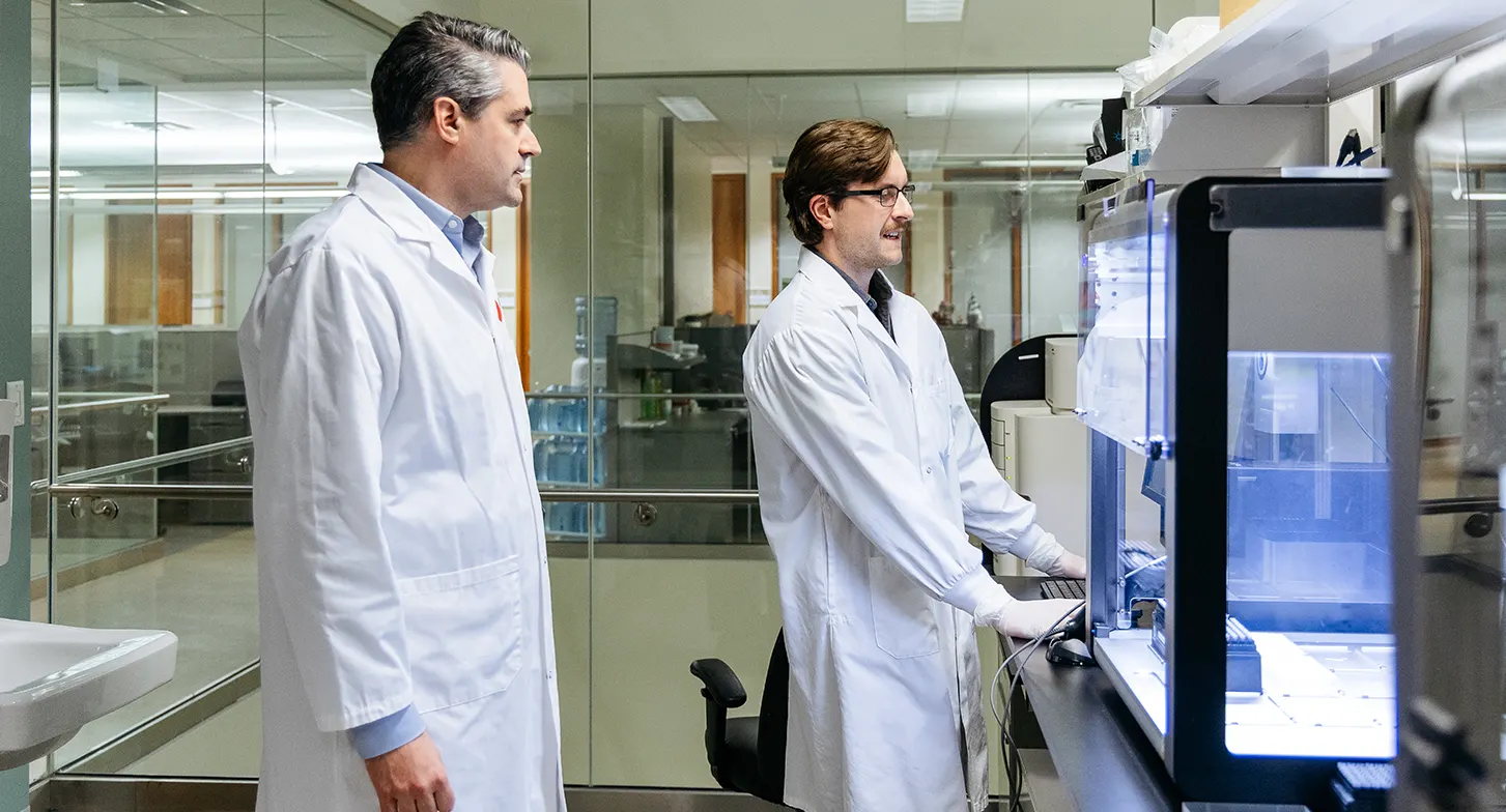 Le Dr Guillaume Paré discute avec son assistant de recherche au laboratoire.