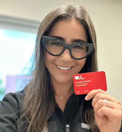 Julie Pfeffer tient sa carte d’instructrice de SIR de Cœur + AVC.