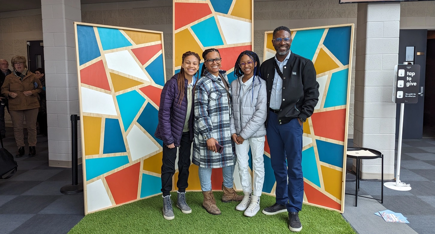 Katherine et sa famille devant une grande murale.