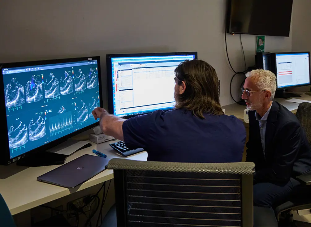 Le Dr Luc Mertens et son assistant de recherche examinent des images à l’ordinateur.