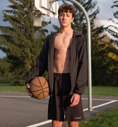  Olivier Lanthier se tient devant un filet de basket extérieur tenant un ballon de basket