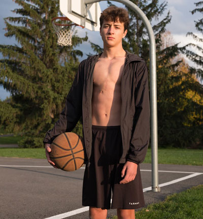 Olivier Lanthier se tient devant un filet de basket extérieur tenant un ballon de basket