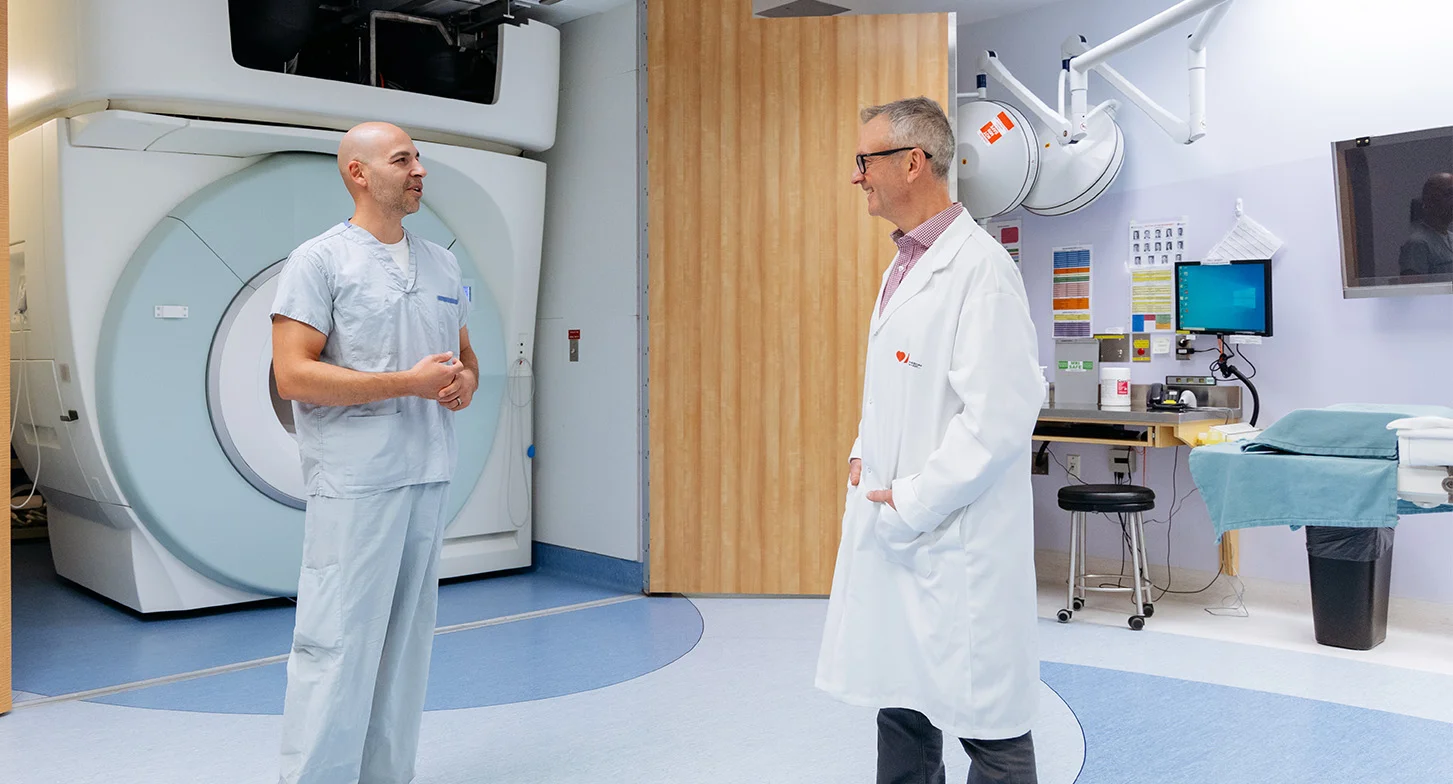 Le Dr Philip Barber discutant avec un collègue près d’un appareil d’IRM.
