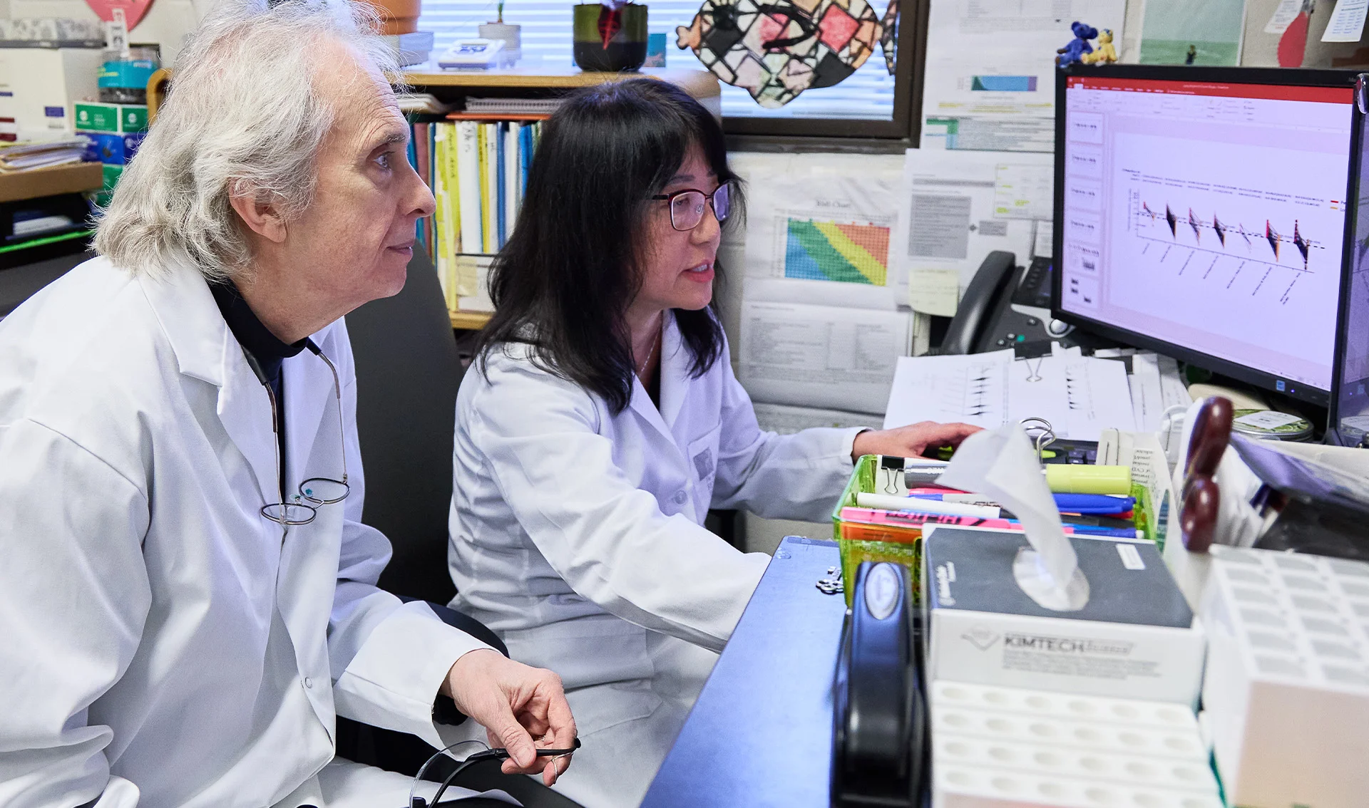 Le Dr Robert Hegele, chercheur subventionné par Cœur + AVC, et son assistant de recherche étudient des données sur un ordinateur dans leur laboratoire.
