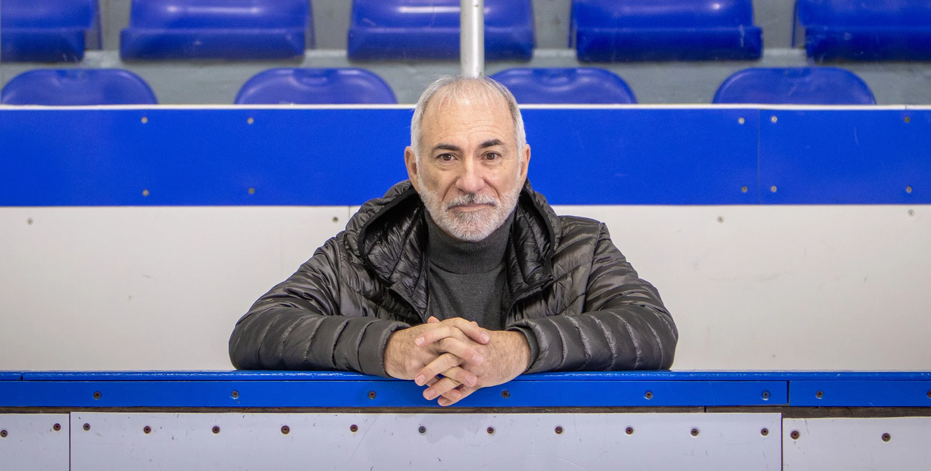 Robert Marien, survivant d’un arrêt cardiaque, s’appuie sur un banc dans un aréna.