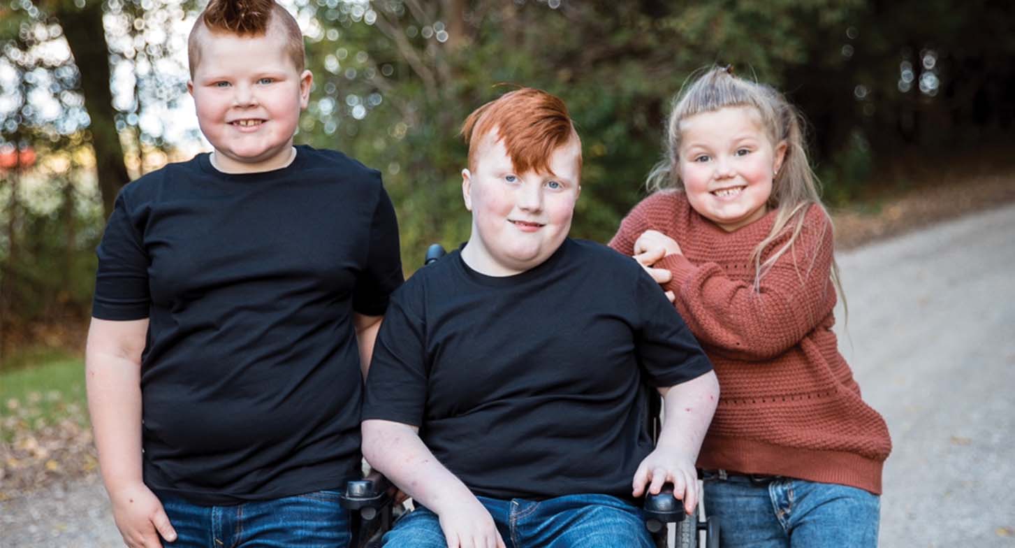 Seth en fauteuil roulant, son frère et sa soeur à ses côtés.
