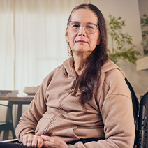 Lynne assise dans son fauteuil roulant.