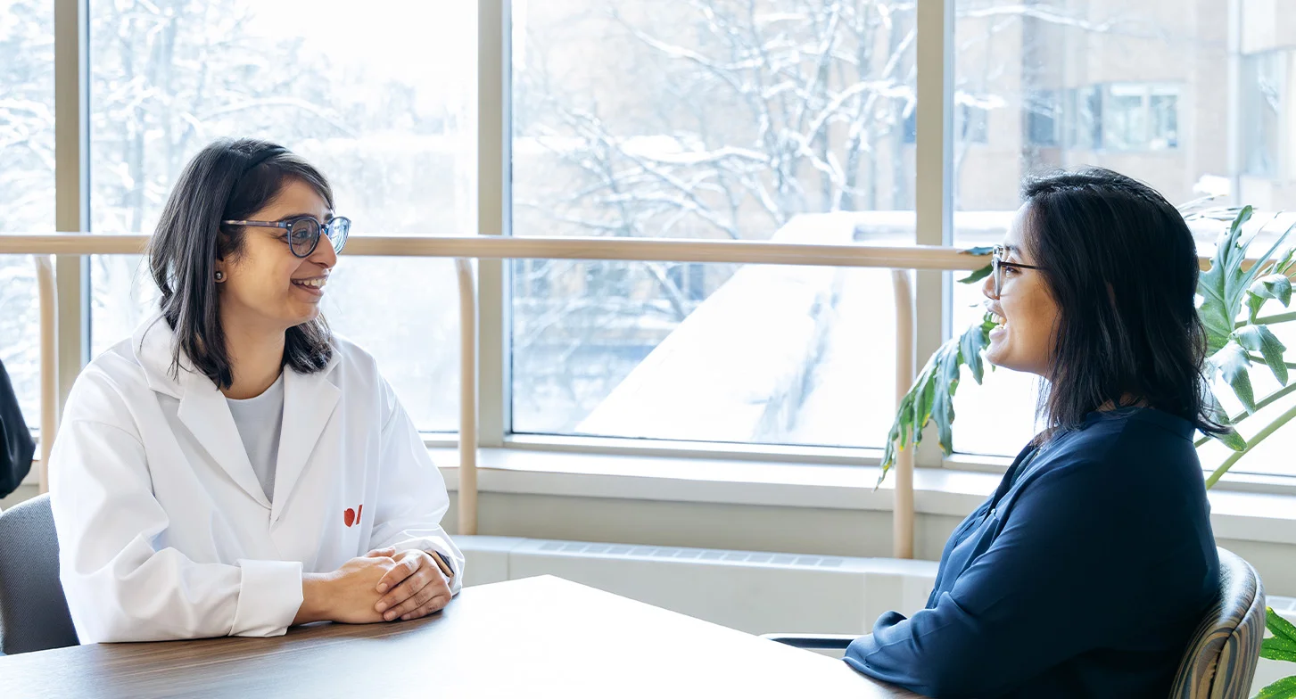 Swati Mehta et l’étudiante qu’elle supervise au doctorat discutent, assises à une table.