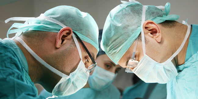 Trois chirurgiens effectuant une opération.