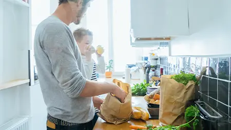 Un père et son fils préparent un repas dans la cuisine.