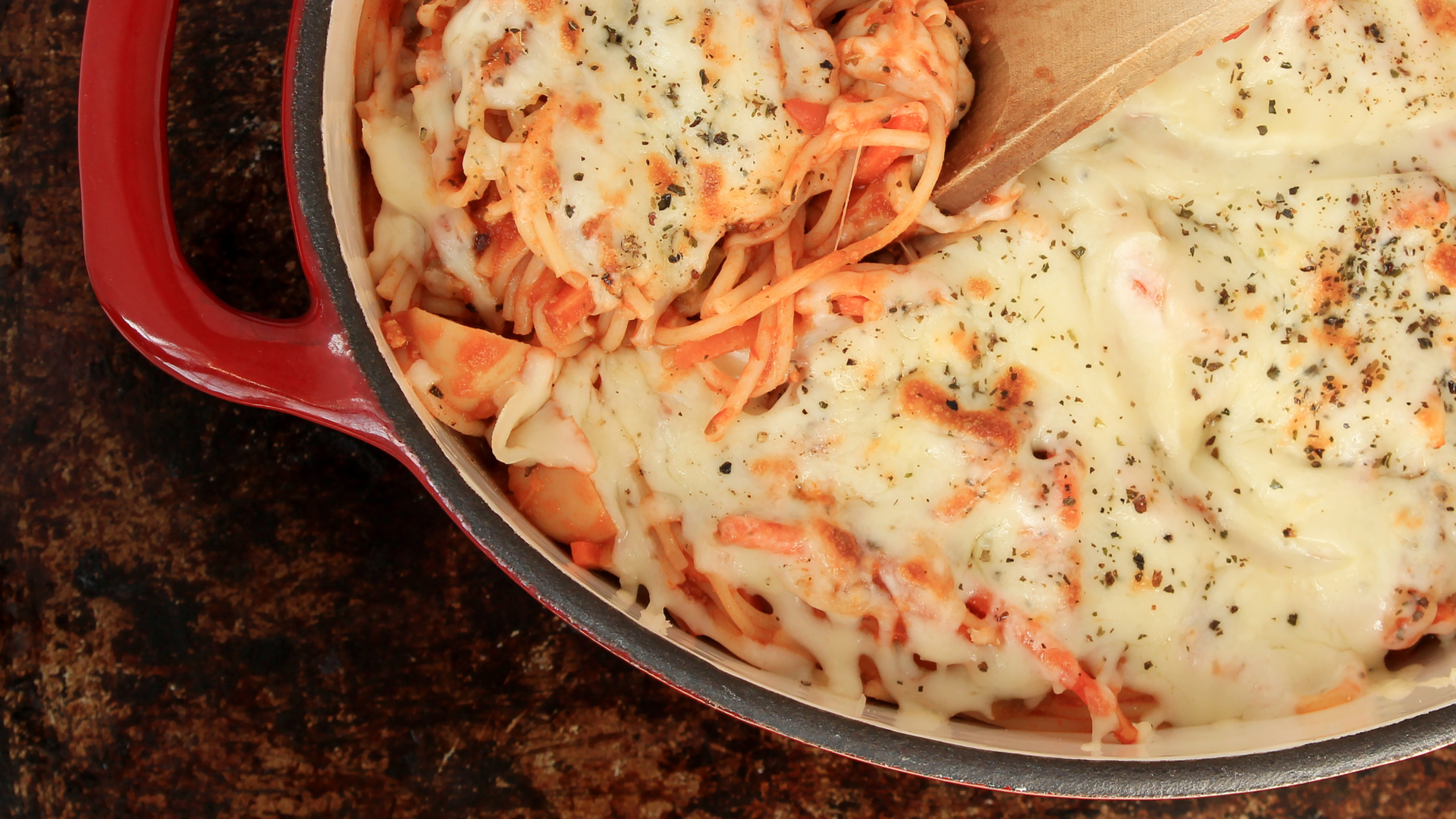 Spaghetti with cheese baked in a red dutch oven